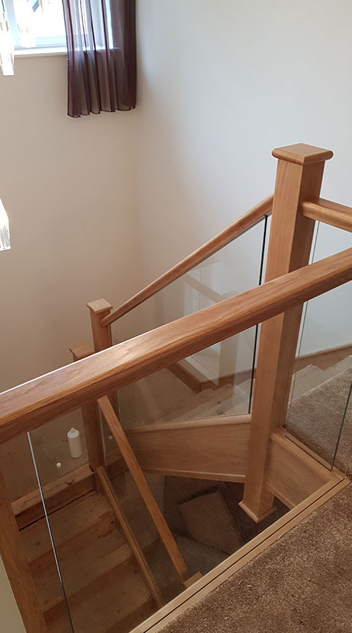 A staircase with oak hand and base plates with seamless oak panels